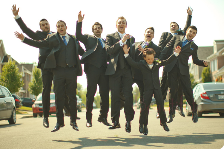 groom jumping with his ushers and ring barer.