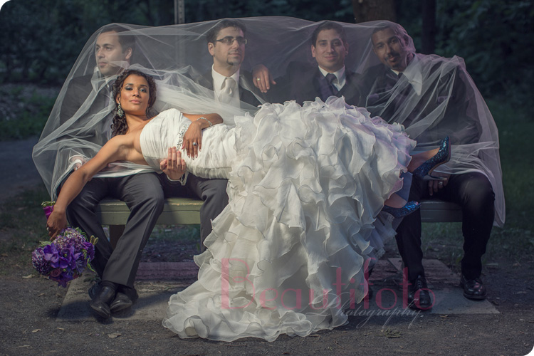 bride posing on a bench with the ushers