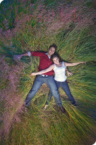 engagement session: the couple lay down in the grass