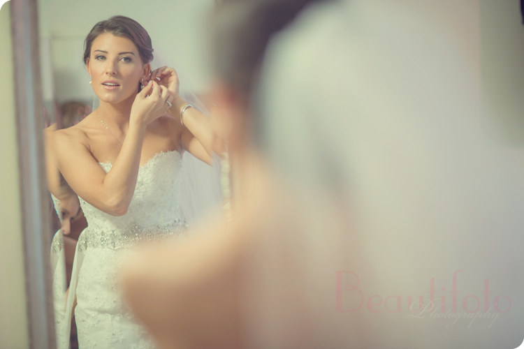 the bride putting on her earrings