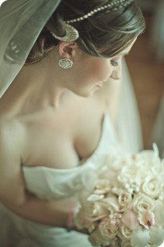 Bride posing with her bouquet in natural light. Photographer: Beautifoto