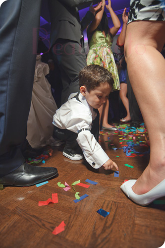 boy picking up confetti from the dance floor. Photo by Beautifoto Montreal wedding photographer.